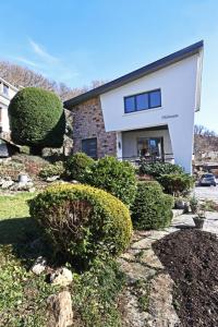 Uma casa com um monte de arbustos à frente. em Villa Fantasia em Spa