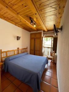 a bedroom with a bed and a wooden ceiling at Hostal Restaurante Serrania in Tragacete