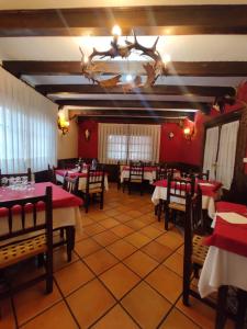 a restaurant with tables and chairs and a chandelier at Hostal Restaurante Serrania in Tragacete