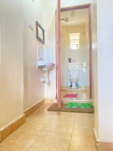 La salle de bains est pourvue de toilettes blanches et d'un lavabo. dans l'établissement The Cream Loft, à Eldoret