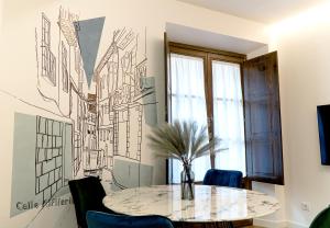 ein Esszimmer mit einem Tisch und einer Wandzeichnung in der Unterkunft Cervantes 5 Collection Delux - Toletum in Toledo