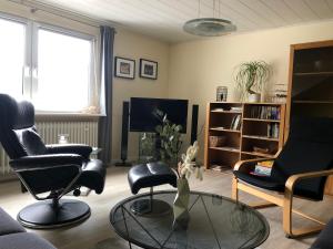 a living room with black chairs and a glass table at Grandezza Ferienwohnungen Erpeldinger in Ellenz-Poltersdorf