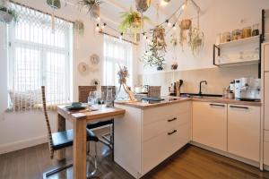 a kitchen with white cabinets and a wooden table at EXKLUSIV home & business Deluxe Kregel Apartment 70qm in Leipzig
