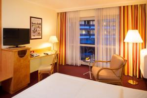 ACHAT Hotel Kaiserhof Landshut في لاندشوت: غرفه فندقيه بسرير ونافذه