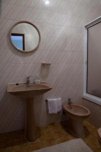 a bathroom with a sink and a toilet and a mirror at A Muralha in Almeida