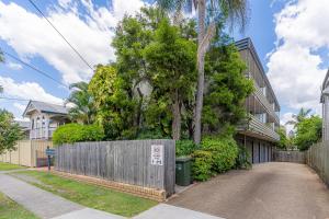 a street in a house with a fence and trees at Fresh 2BD Koala Condo West End in Brisbane