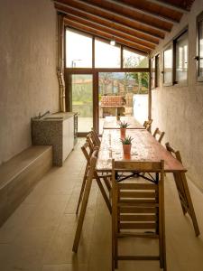 una habitación con una larga mesa de madera y sillas en Casa Iria en Lousame