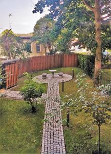 a brick path in a yard with a table and a fence at EXKLUSIV home & business Deluxe Kregel Apartment 70qm in Leipzig