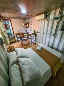 a room with a bed and a table in it at Pousada Cipó Container Chalés Privativos com lareira - Centro da cidade in Serra do Cipo