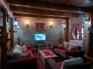 a living room with couches and a flat screen tv at Kuća za odmor Grujić in Kolašin