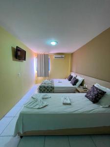 a hotel room with two beds and a television at Executivo Prime Hotel in Teresina
