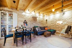 a living room with a couch and a table and chairs at Mala House - Šolta Island in Grohote