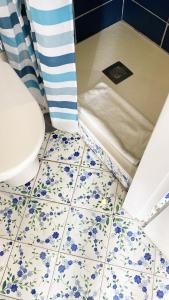 a bathroom with a toilet and blue flowers on the floor at Capri Suite on the beach in Capri