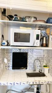 a kitchen with a sink and a microwave at Capri room on the beach in Capri