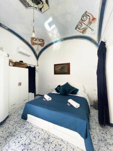 a bedroom with a blue bed with two towels on it at Capri room on the beach in Capri