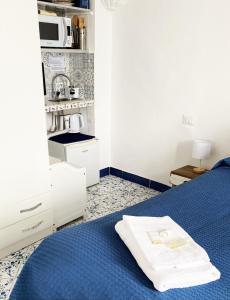 a bedroom with a blue bed with a microwave at Capri room on the beach in Capri