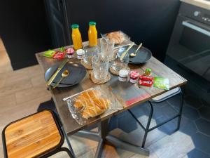 Need'Amour - Suite chaleureuse في بونتولت-كومْبو: طاولة خشبية عليها طعام ومشروبات