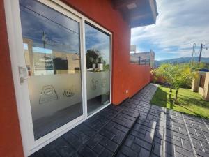 a glass door of a building with a window at Los 4 elementos in La Falda