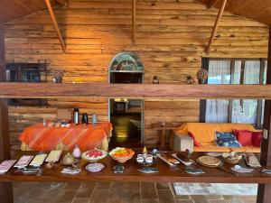 a wooden cabin with a table with food on it at Pousada Refúgio dos Falcões in Nova Friburgo