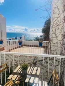 a balcony with a table and a view of the ocean at Hostal Tres Soles in Nerja