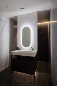 een badkamer met een wastafel en een spiegel bij HOUSE38 Panoramic View Apartments SELF CHECK-IN in Kaunas