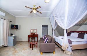 a bedroom with a bed and a ceiling fan at Dzimbahwe Guest Lodge in Victoria Falls