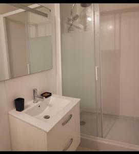 Ile de Saint-Nicolas T2 et/ou Ile de Penfret Studio في فوسنان: حمام أبيض مع حوض ودش