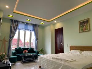 1 dormitorio con cama, sofá y ventana en An Na Bình Homestay en Hoi An