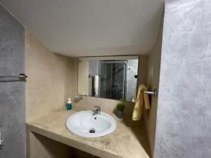 a bathroom with a sink and a mirror at Tia Nita Apartamentos in Mindelo