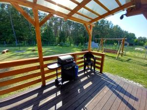 a grill on a deck with a playground at Ostoja Spokoju in Sucha Rzeczka
