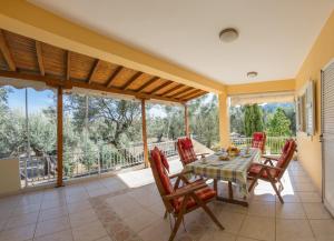 a dining room with a table and chairs on a balcony at oli terra in Lefkada