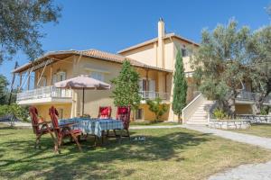 a house with a table and chairs in the yard at oli terra in Lefkada