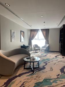 歐拉的住宿－فندق الوتين ALwateen Hotel，客厅配有沙发和桌子