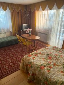 a hotel room with a bed and a table and a tableablish at Noclegi u Janika in Mizerna