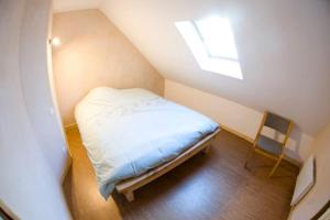 - un petit lit dans une petite chambre avec fenêtre dans l'établissement Gite Staufen, à Thann