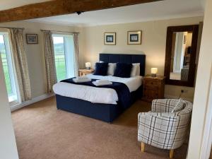 a bedroom with a large bed and a chair at The Coppleridge Inn in Motcombe