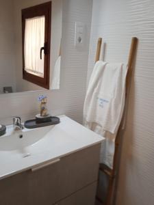 ein Bad mit einem Waschbecken, einem Spiegel und einem Handtuch in der Unterkunft Apartamento Turístico El Empedrado de M&G in Colmenar de Oreja