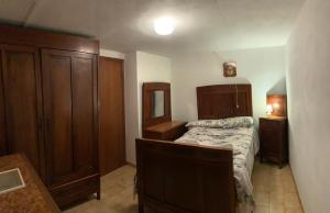 um quarto com uma cama com uma cabeceira em madeira e armários em madeira em La casa di UGO em Ciglione