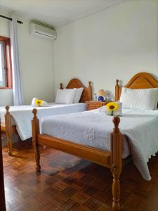a bedroom with two beds with yellow flowers on them at Anoitecer Itinerante AL - antiga residencial o garfo in Ponte de Lima
