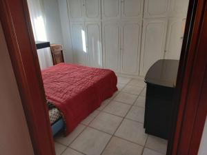 - une chambre avec un lit doté d'une couverture rouge et d'une table dans l'établissement CASA LOLA, à Livourne