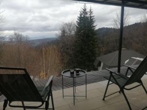 a patio with two chairs and a table and a tree at Apartmani Milosevic in Kopaonik