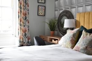um quarto com uma cama, uma cadeira e um espelho em Chestnut Bed and Breakfast em Bourton on the Water