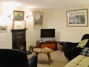 sala de estar con TV y chimenea en Ashlyn, en Whitehills