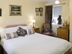 a bedroom with a large white bed and a chair at Ashlyn in Whitehills