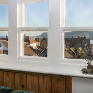 three windows in a room with a view of a town at Falconhurst in Robin Hood's Bay