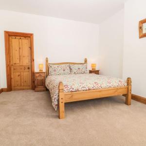 a bedroom with a wooden bed with a wooden door at Falconhurst in Robin Hood's Bay