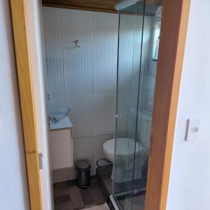 uma casa de banho com um WC e uma cabina de duche em vidro. em Casa 4/4 com piscina. em Maricá