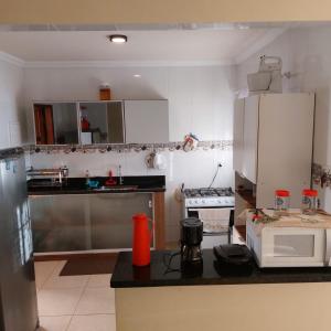 een keuken met een aanrecht en een magnetron bij Casa 4/4 com piscina. in Maricá