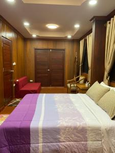 um quarto com uma cama grande e uma cadeira vermelha em 188 Teak House บ้านต้นสัก em Chiang Mai