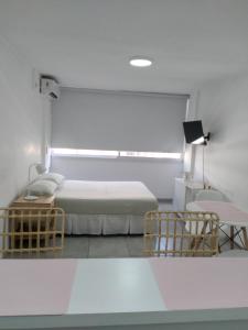 1 dormitorio con 2 camas, mesa y sillas en Alquiler temporario Céntrico La Plata en La Plata